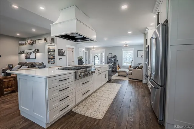 a kitchen with stainless steel appliances kitchen island granite countertop a stove and a refrigerator