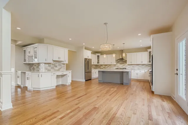 a large kitchen with a center island stainless steel appliances and cabinets