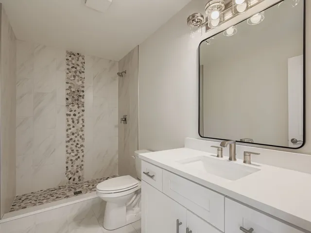 a bathroom with a sink toilet and shower