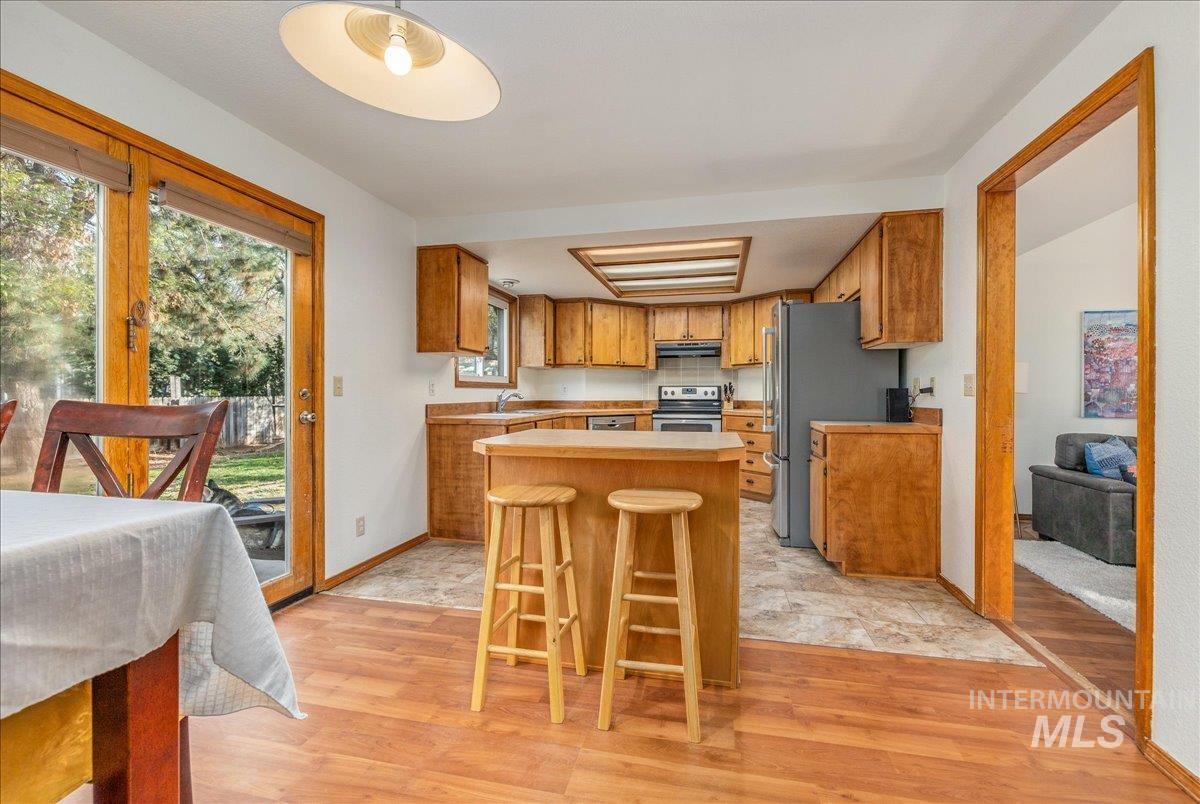 236 East Bayview Court Boise, ID 83706 - Photo 12 of 49 Kitchen with wood finish cabinets, stainless steel appliances, a breakfast bar area, light wood finished floors, and a center island