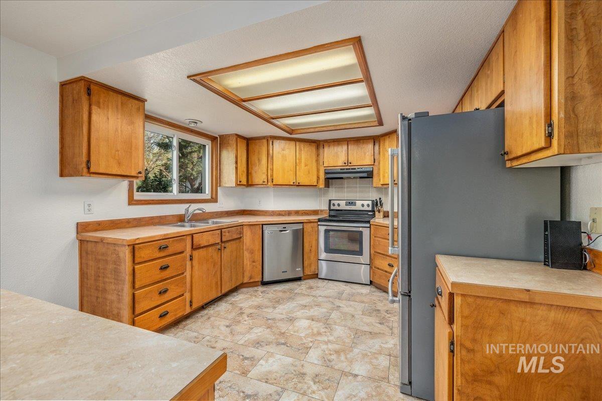 236 East Bayview Court Boise, ID 83706 - Photo 13 of 49 Kitchen featuring light countertops, stainless steel appliances, and wood finish cabinetry