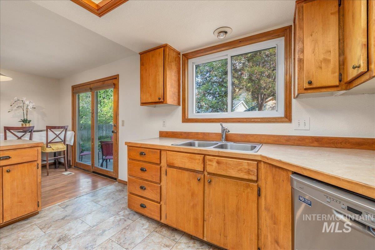 236 East Bayview Court Boise, ID 83706 - Photo 18 of 49 Kitchen with light countertops, dishwasher, and wood finish cabinets