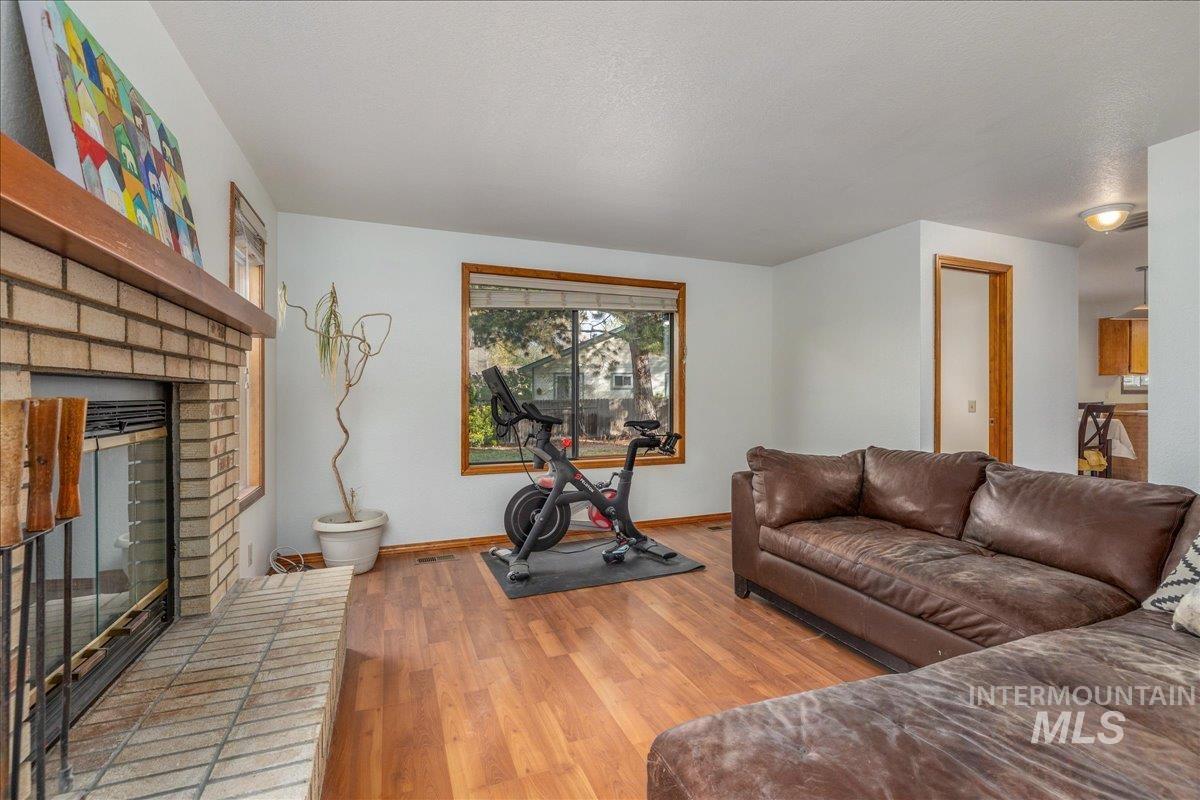 236 East Bayview Court Boise, ID 83706 - Photo 25 of 49 Living area featuring light wood finished floors, a brick fireplace, and a textured ceiling