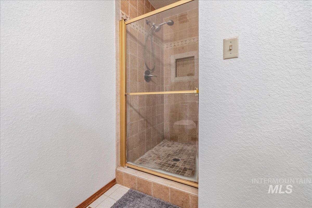 236 East Bayview Court Boise, ID 83706 - Photo 32 of 49 Full bathroom with a textured wall, a stall shower, and light tile patterned floors