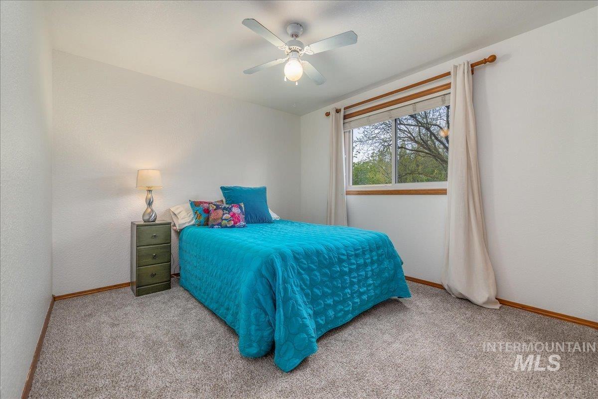 236 East Bayview Court Boise, ID 83706 - Photo 35 of 49 Bedroom featuring ceiling fan, light colored carpet, and a textured wall