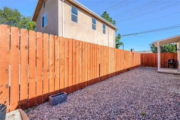 a view of a backyard with wooden fence