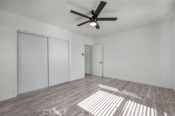 a view of a livingroom with a ceiling fan & wooden floor