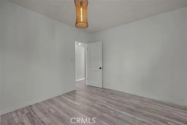 a view of an empty room with wooden floor and windows