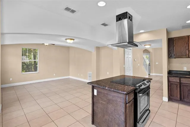 a kitchen with granite countertop a sink a stove and a refrigerator