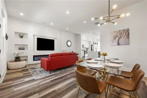 a living room with furniture a flat screen tv and kitchen view