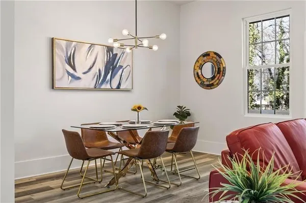 a view of a dining room with furniture a rug and wooden floor