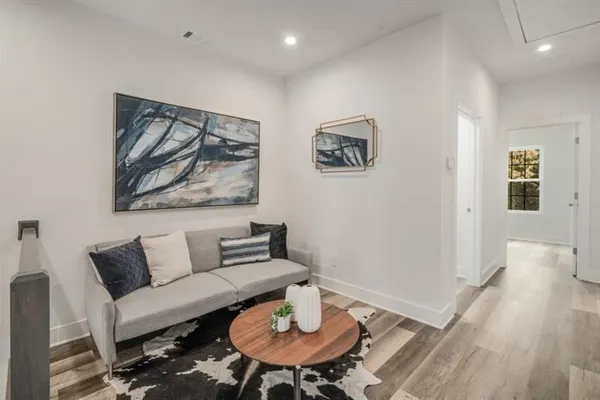 a living room with furniture and a wooden floor