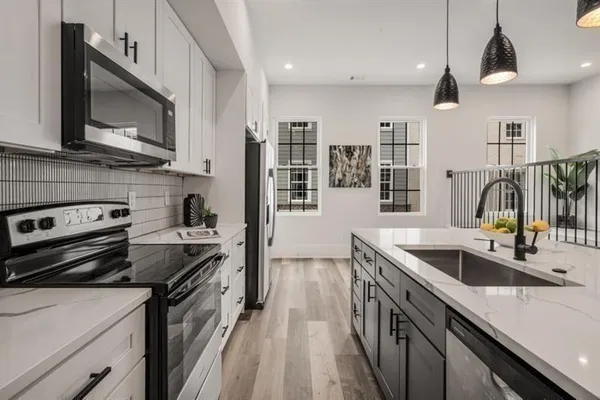 a kitchen with stainless steel appliances granite countertop a sink stove and refrigerator