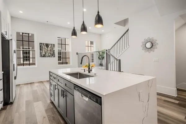 a kitchen with a sink a stove and wooden floor