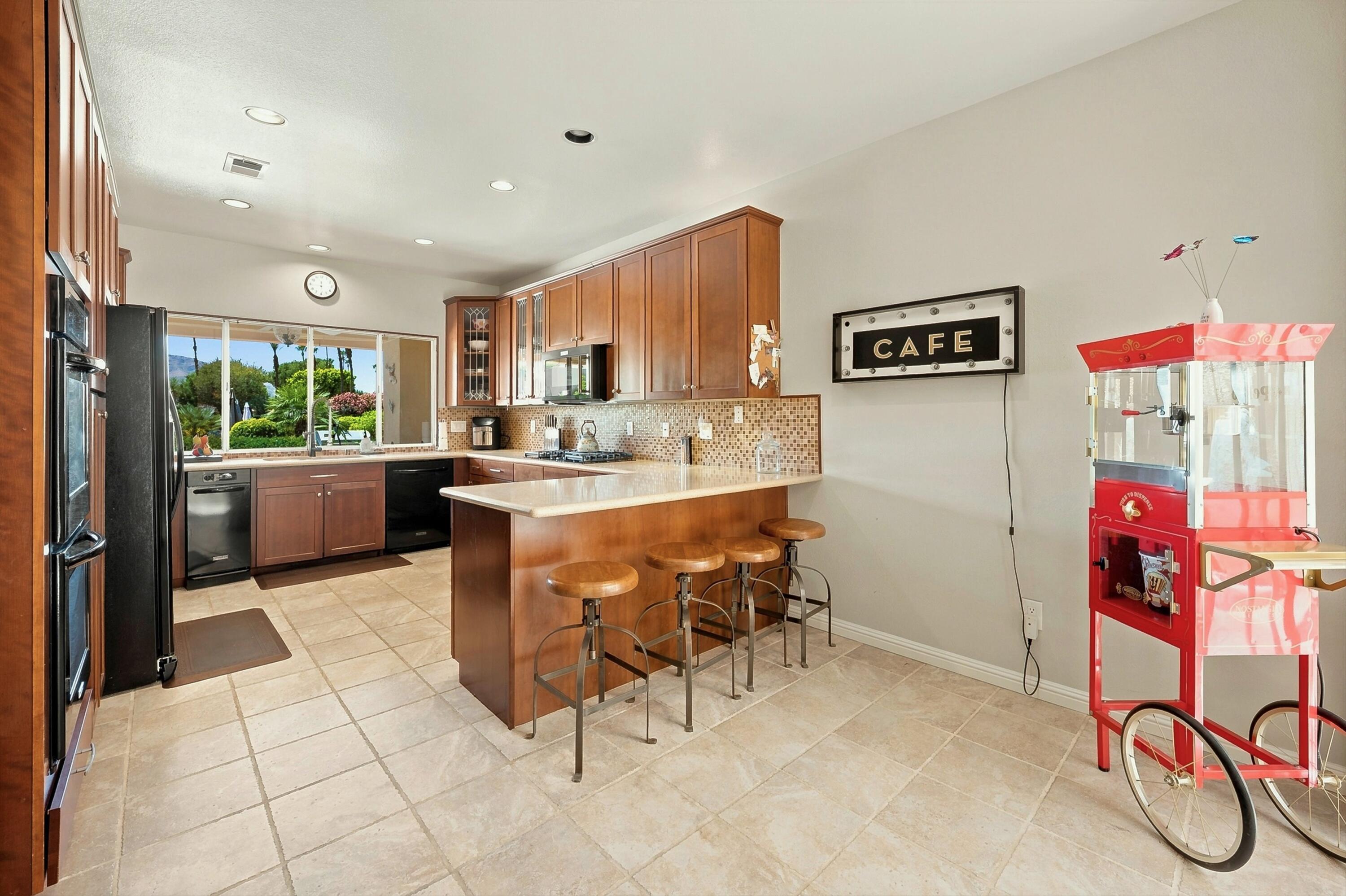 138 Lakeshore Drive Rancho Mirage, CA 92270 - Photo 6 of 30 a kitchen with stainless steel appliances kitchen island granite countertop a sink and cabinets