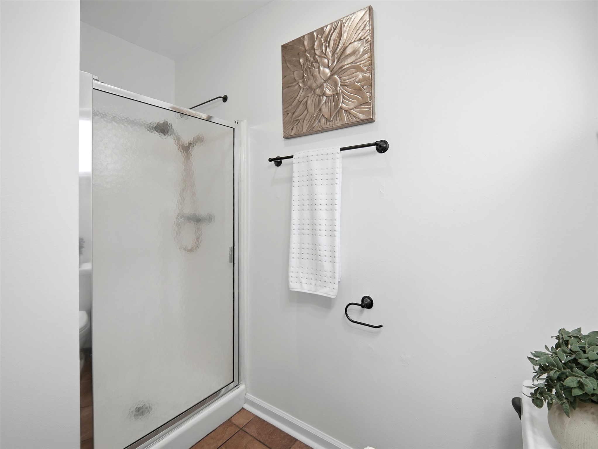 7001 Windrift Way Austin, TX 78745 - Photo 14 of 17 A well-appointed shower with a clear enclosure, offering modern convenience and a crisp aesthetic.