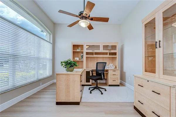 a view of a workspace with furniture and a window