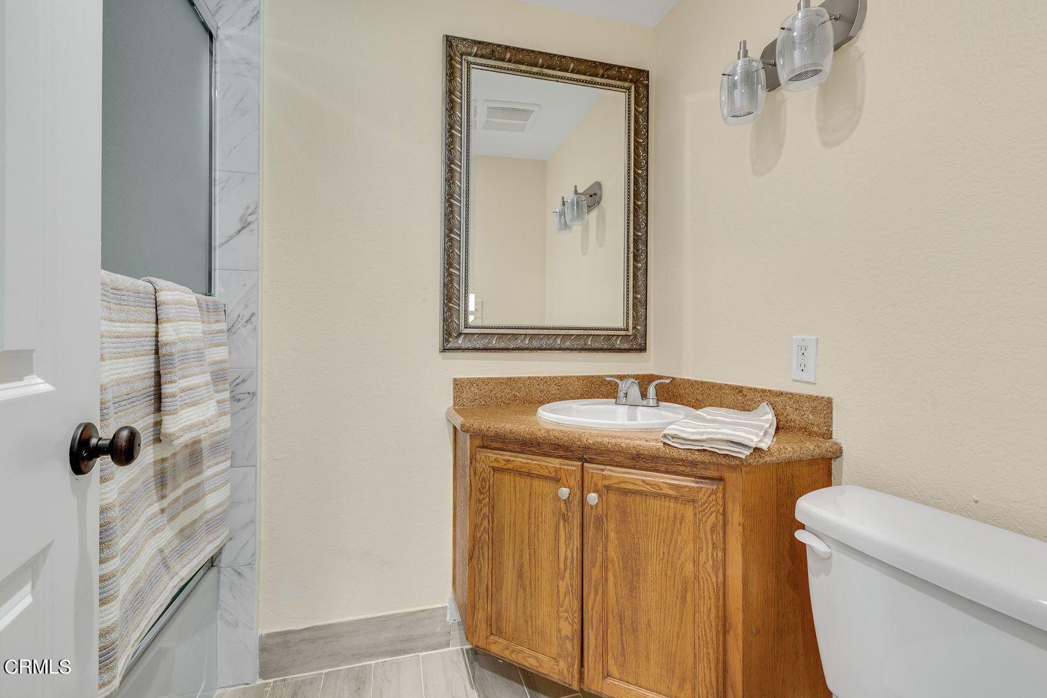 2864 Racine Street Simi Valley, CA 93065 - Photo 22 of 32 a bathroom with a granite countertop sink toilet and shower