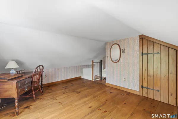 a view of a room with wooden floor and furniture