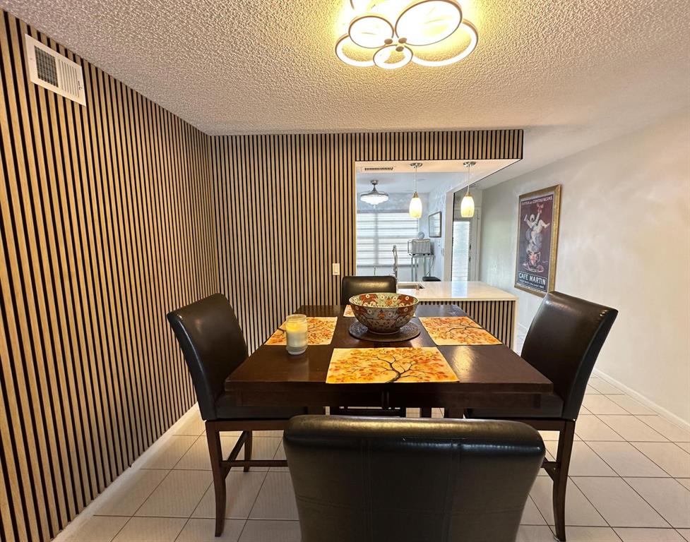 4301 Martinique Circle, Unit H2 Coconut Creek, FL 33066 - Photo 5 of 37 Dining Room With Accent Wood Wall