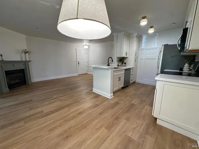 a kitchen with a sink cabinets and wooden floor