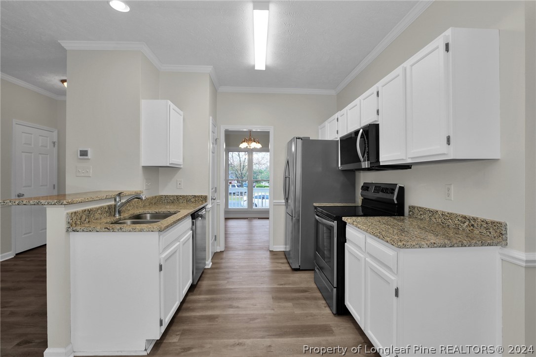4780 Deer Lakes Road Fayetteville, NC 28311 - Photo 11 of 36 a kitchen with stainless steel appliances granite countertop a stove top oven a refrigerator a sink and dishwasher with white cabinets