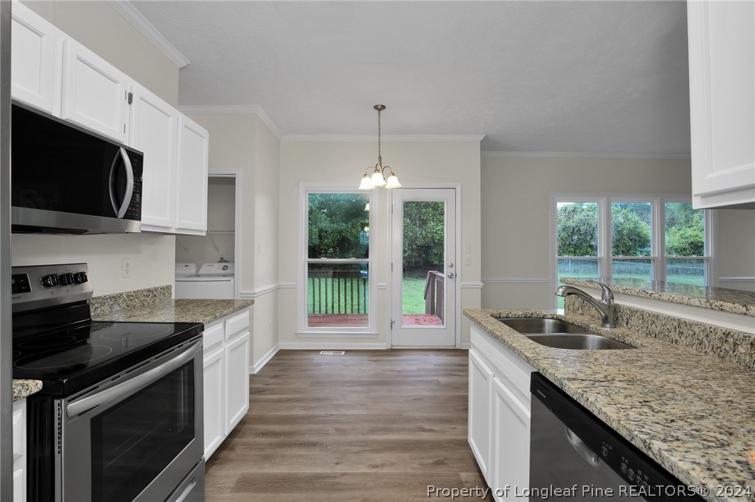 4780 Deer Lakes Road Fayetteville, NC 28311 - Photo 13 of 36 a kitchen with granite countertop a stove and a sink