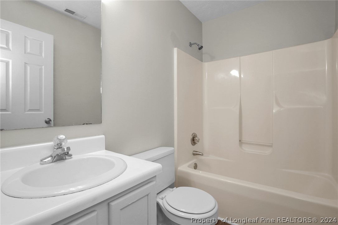 4780 Deer Lakes Road Fayetteville, NC 28311 - Photo 23 of 36 a bathroom with a toilet a sink a mirror and bathtub