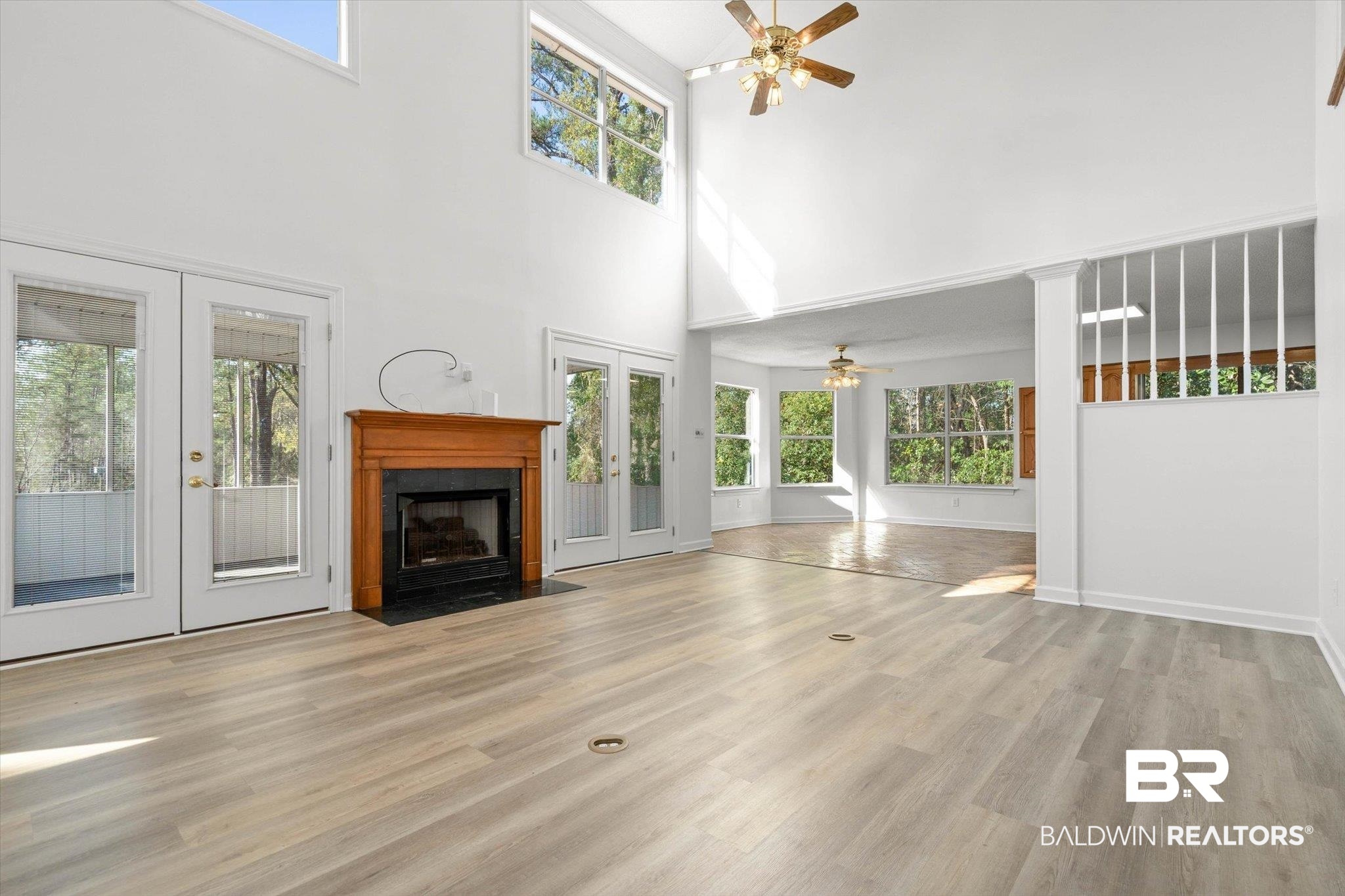 3847 Riviere Du Chien Road Mobile, AL 36693 - Photo 10 of 51 Unfurnished living room with french doors, a ceiling fan, light wood finished floors, plenty of natural light, and a high ceiling