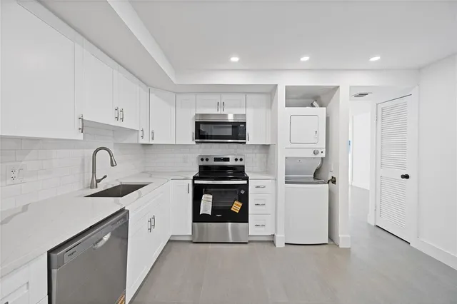 a kitchen with white cabinets and stainless steel appliances