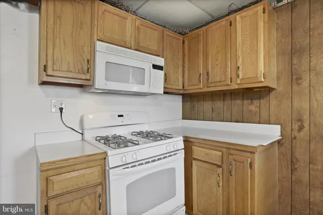 a kitchen with stainless steel appliances granite countertop a stove a microwave oven and a white cabinets