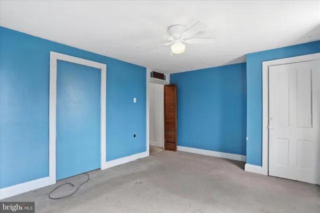 a view of an empty room with a chandelier fan