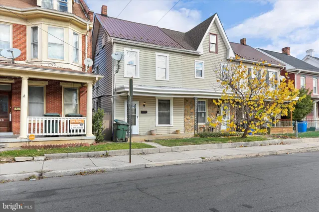front view of a brick house with a yard