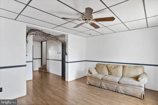 a living room with furniture and a ceiling fan