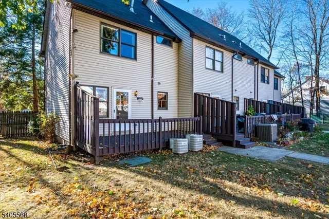a view of a house with wooden fence and a large tree