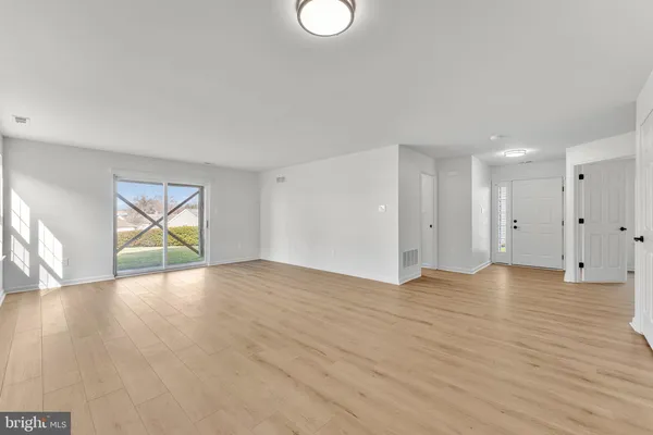 a view of empty room with wooden floor and window