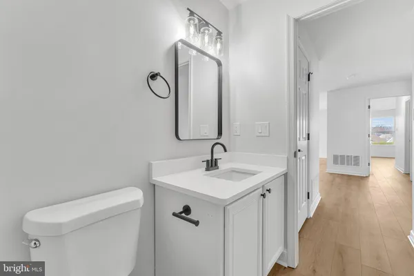 a bathroom with a sink and mirror with toilet
