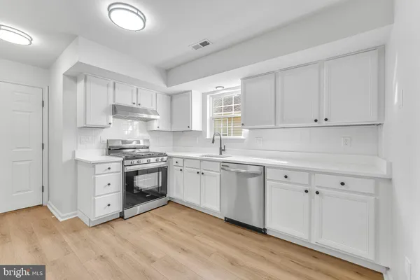 a kitchen with granite countertop white cabinets and white appliances