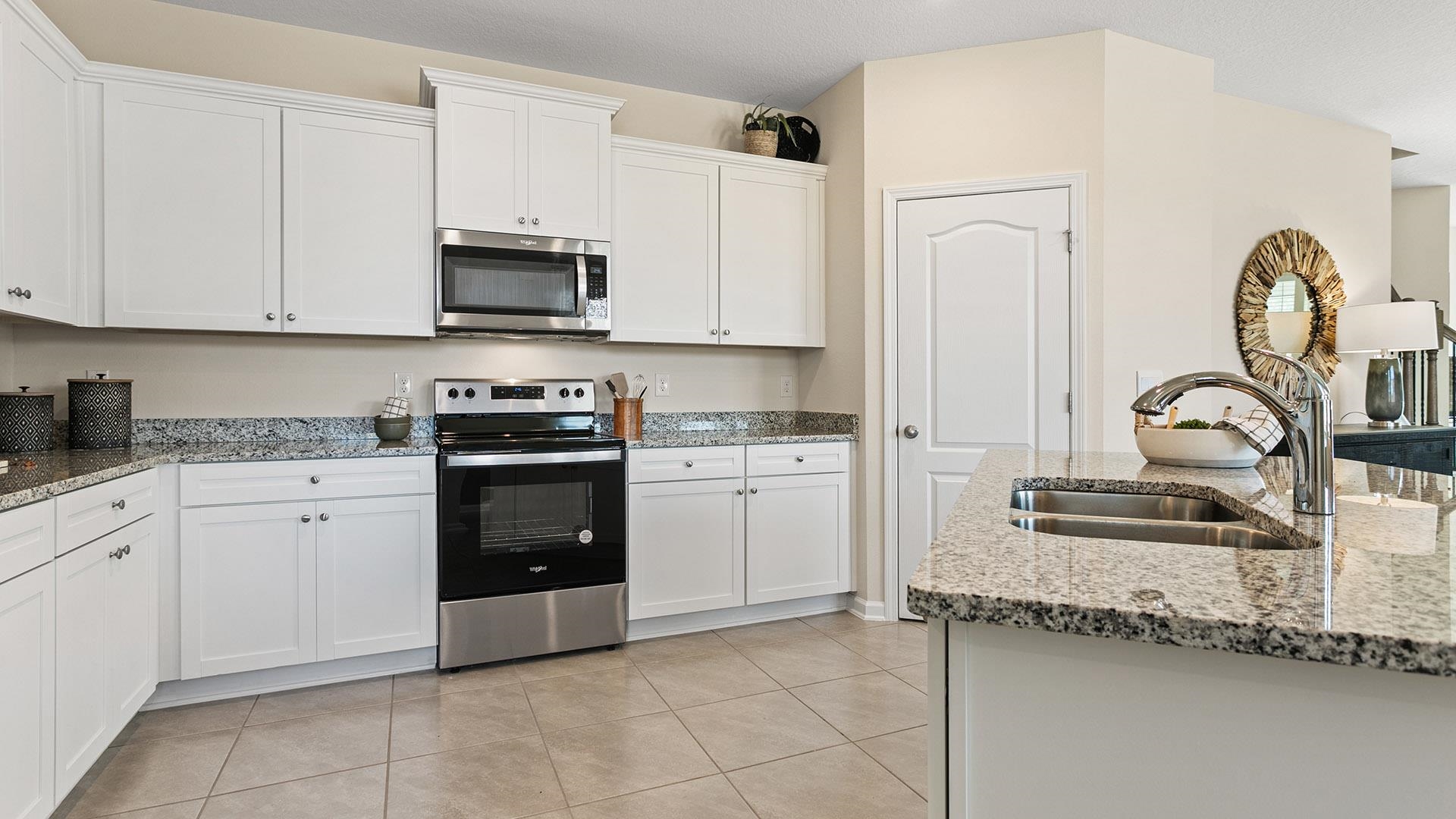 302 Redbud Road Palm Coast, FL 32137 - Photo 6 of 39 a kitchen with granite countertop white cabinets and stainless steel appliances