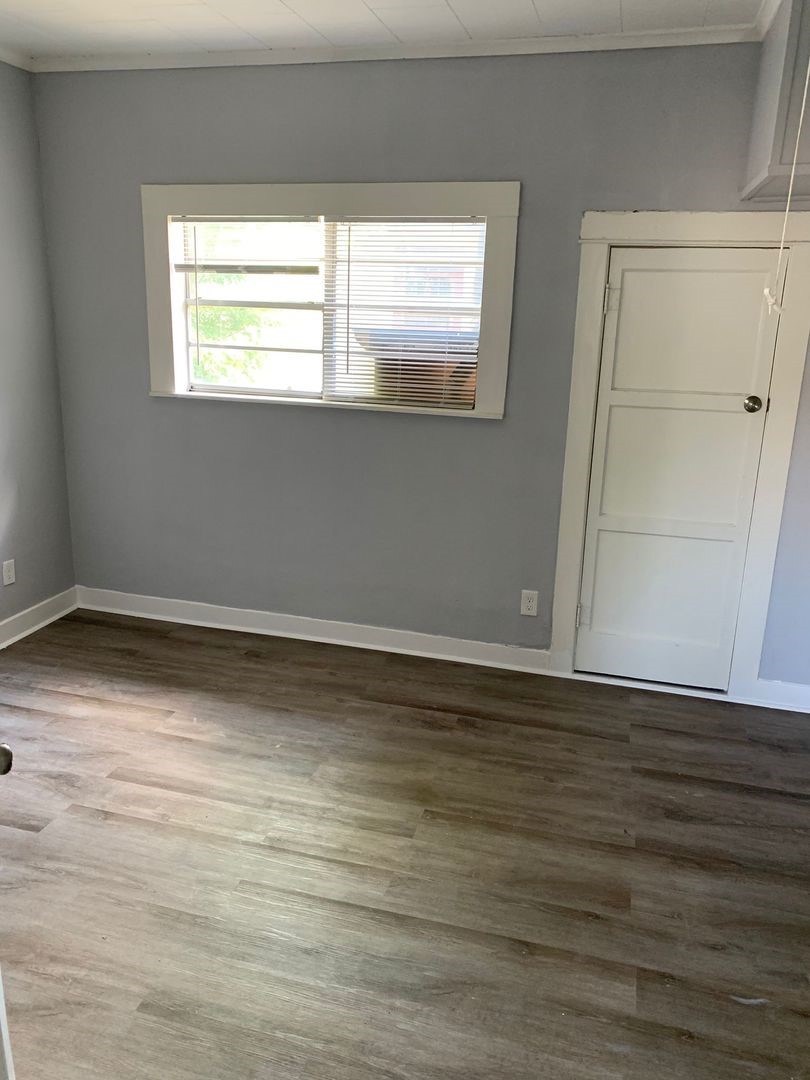 1409 10th Street Port Arthur, TX 77640 - Photo 3 of 11 a view of an empty room with wooden floor and a window