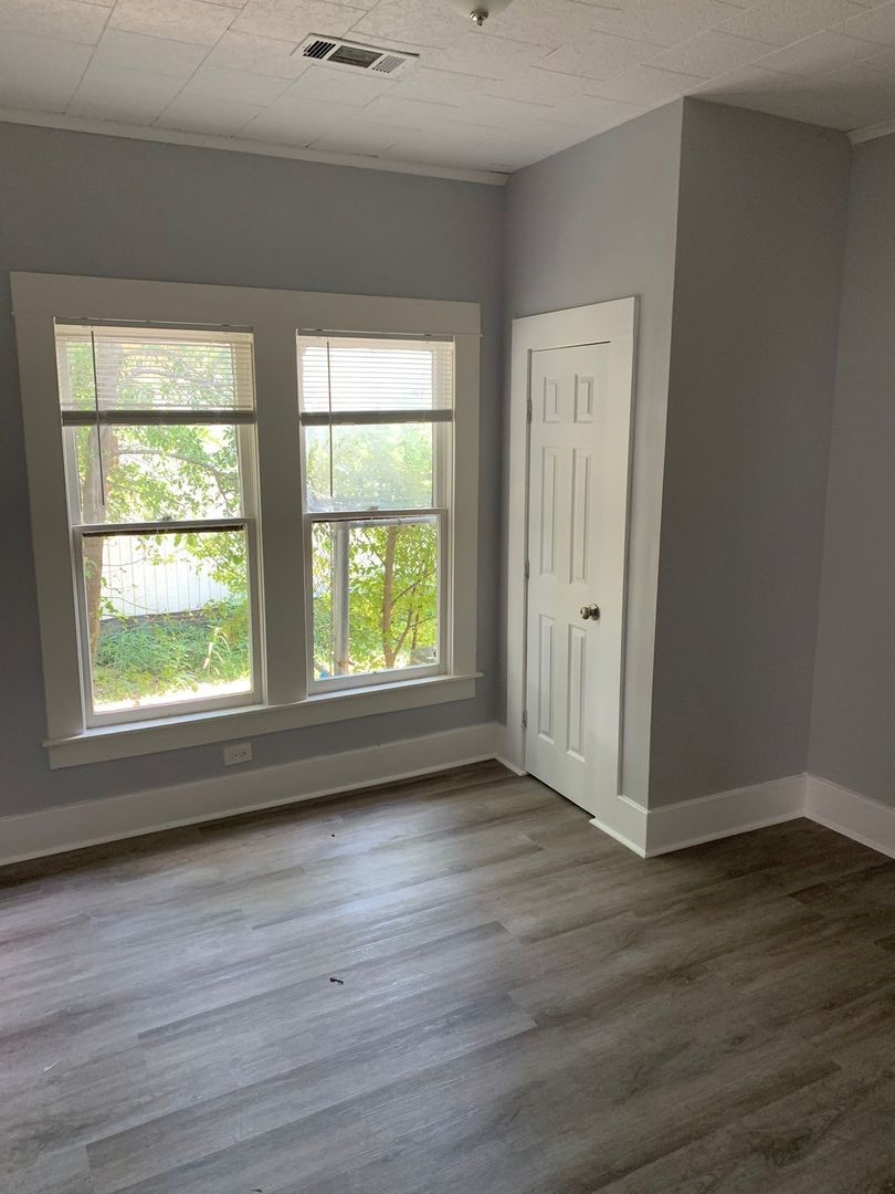 1409 10th Street Port Arthur, TX 77640 - Photo 4 of 11 a view of an empty room with wooden floor and a window
