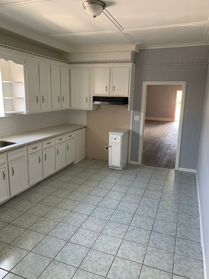 1409 10th Street Port Arthur, TX 77640 - Photo 6 of 11 a kitchen with cabinets and window
