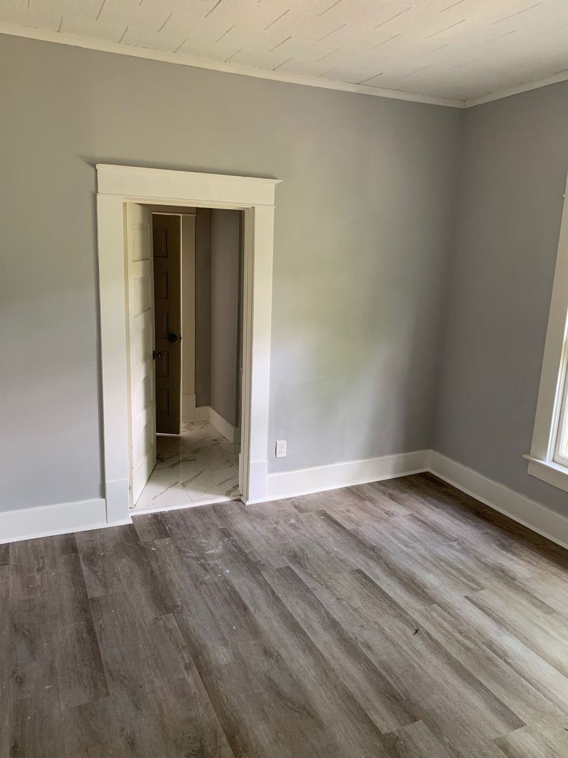 1409 10th Street Port Arthur, TX 77640 - Photo 9 of 11 a view of an empty room with wooden floor and a window