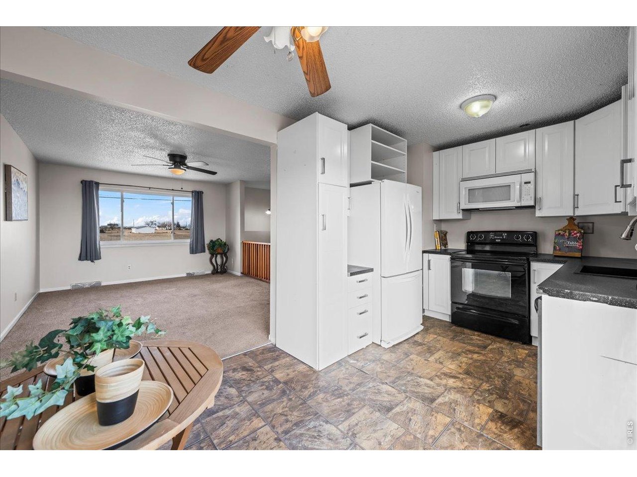516 West Main Street Pierce, CO 80650 - Photo 8 of 24 a kitchen with stainless steel appliances kitchen island granite countertop a refrigerator and a stove top oven