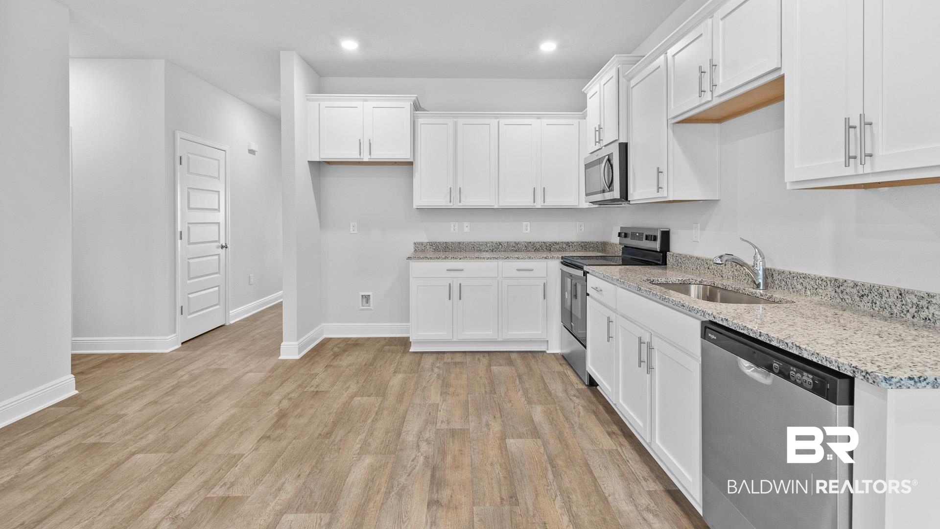 13356 Shea Circle Foley, AL 36535 - Photo 3 of 15 Kitchen featuring white cabinetry, speckled countertops, stainless steel appliances, and wood-finish flooring