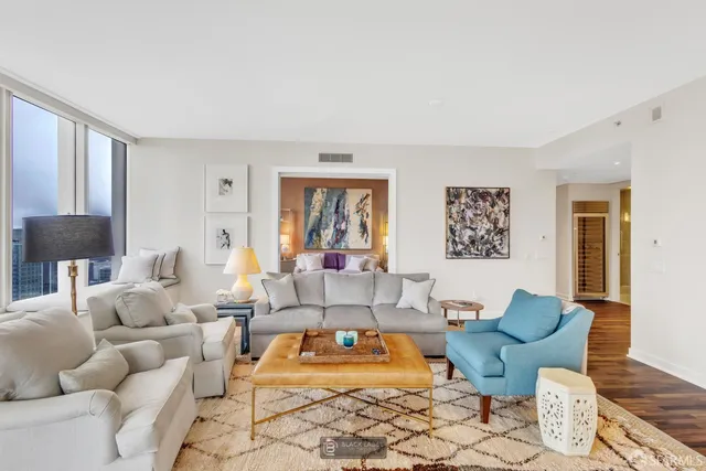 a living room with furniture and a wooden floor