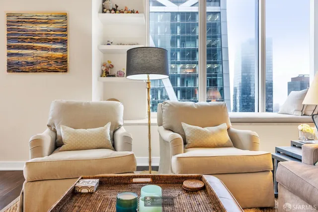 a living room with furniture a large window and wooden floor