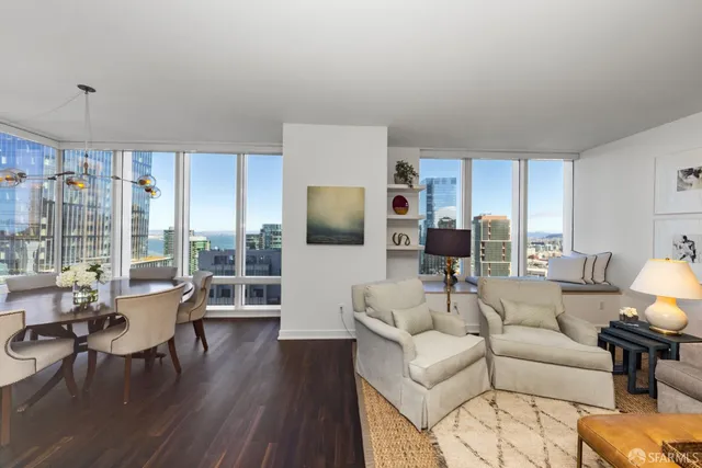 a living room with furniture wooden floor and a large window