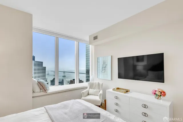 a bedroom with furniture and a large window