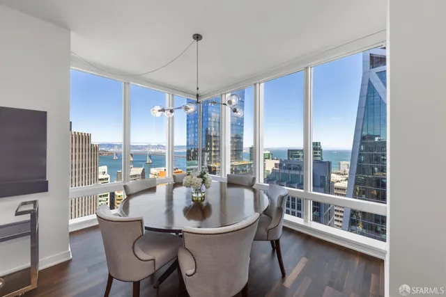 a dining room with furniture a chandelier and wooden floor